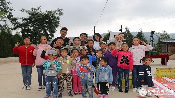 9d04d1074614cc43d15fb677a1421c8b.jpg 图13 甘肃研支团成员与贫困村教学点学生合影.jpg
